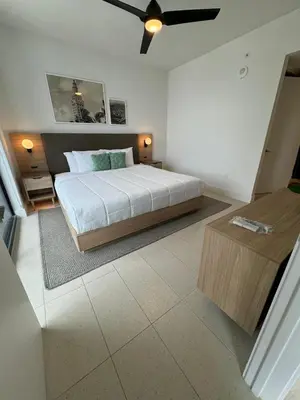 a bedroom with a large bed and a table at New Luxury Apartment at Downtown Miami in Miami