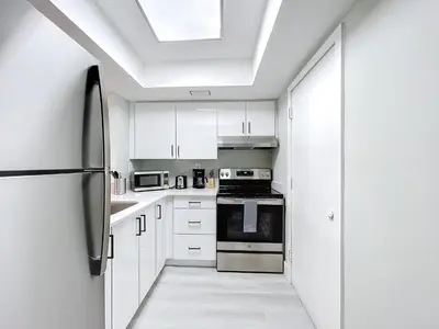 a kitchen with white cabinets and a black refrigerator at Cordova Arms By Rocketstay in Fort Lauderdale