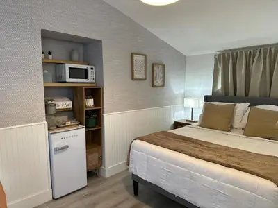 a bedroom with a bed and a microwave on a shelf at Cozy Corner in Miami