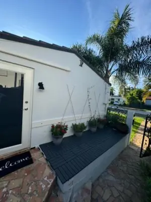 a patio with potted plants next to a white building at Cozy Corner in Miami