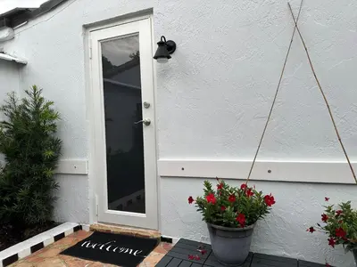 a door of a house with flowers in a pot at Cozy Corner in Miami