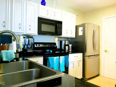 a kitchen with a sink and a stainless steel refrigerator at The Costal, stunning water view apartment at Aventura Yacht Club, Miami Florida! in Sun Swept Isles