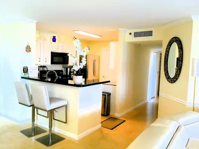 a kitchen with a counter and a bar in a room at The Costal, stunning water view apartment at Aventura Yacht Club, Miami Florida! in Sun Swept Isles