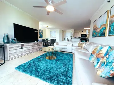 a living room with a white couch and a flat screen tv at The Costal, stunning water view apartment at Aventura Yacht Club, Miami Florida! in Sun Swept Isles