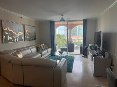 a living room with a couch and a television at The Costal, stunning water view apartment at Aventura Yacht Club, Miami Florida! in Sun Swept Isles