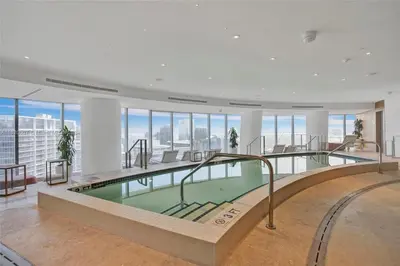 a large swimming pool in a building with windows at ASTON MARTIN TOWER Miami in Miami