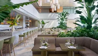 a restaurant with couches and a bar with plants at Brickell High Floor AKA Free Parking by Palermo Home Miami in Miami