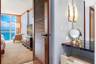a hotel room with a desk and a bedroom at 2 Bedroom Private Residence at Carillon Miami Resort -522 in Miami Beach