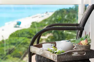 a chair with a tray with coffee cups and plants at 2 Bedroom Private Residence at Carillon Miami Resort -522 in Miami Beach