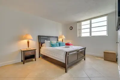 a bedroom with a bed with blue pillows and a window at Hollywood Condo with Beach Access - Walk to Shore! in Hollywood