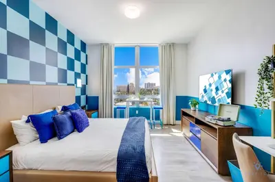 a hotel room with a large bed and a desk at Luxurious Condo with Rooftop Pool Hot Tub in Hollywood