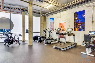a gym with several treadmills and exercise bikes at Luxurious Condo with Rooftop Pool Hot Tub in Hollywood