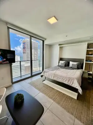 a bedroom with a bed and a large window at Spacious Studio in the Heart of Downtown Miami in Miami