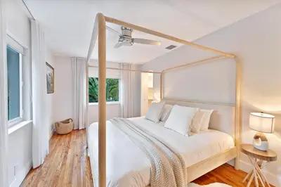 a white bedroom with a canopy bed with a window at Stunning Historic Villa with Jacuzzi Heated Pool and Resort style Backyard in Miami