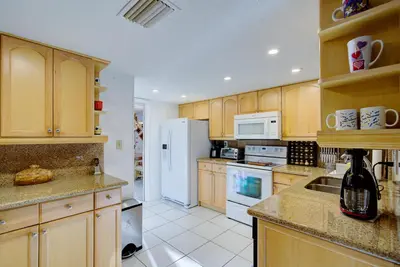 a kitchen with wooden cabinets and a white refrigerator at Classic Modern 3-Bedroom Oasis in Fort Lauderdale