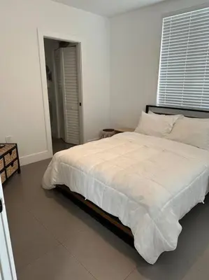 a bedroom with a large bed with white sheets and pillows at Charming House at Miami's Heart in Miami