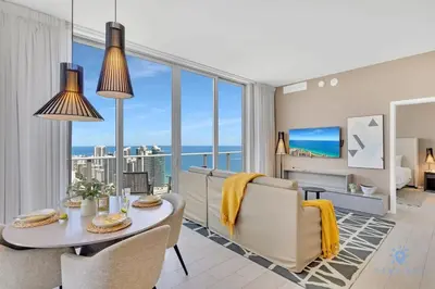 a living room with a table and chairs and a view of the ocean at Penthouse with Free Parking and Beautiful Amenities in Hollywood