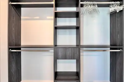 a walk in closet with dark wood and glass shelves at Gorgeous Unit in the Heart of Downtown Miami in Miami