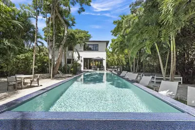 a swimming pool with chairs and a house at The Waterhouse- Amazing Villa With Infinity Pool in Miami