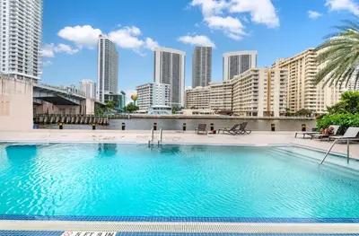 a large swimming pool with a city skyline in the background at Beachwalk Family Studio- Beach Pool Gym & Bay View in Hallandale Beach