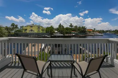 a balcony with chairs and a table and a view of the water at Cozy Retreat in Fort Lauderdale
