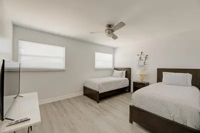 a bedroom with two beds and a cross on the wall at Cozy Retreat in Fort Lauderdale