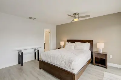 a bedroom with a bed with two tables and a ceiling fan at Cozy Retreat in Fort Lauderdale