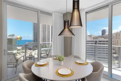a dining room with a table and chairs and large windows at Beautiful apartment with Amazing Pool Balcony in Hollywood