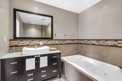 a bathroom with a tub and a sink and a mirror at Spacious 3 bedroom Home with Oversized Pool & Backyard in Miami