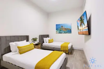 a room with two beds and a painting on the wall at Beautiful Apt 2BR Hollywood Beach Rooftop Pool in Hollywood