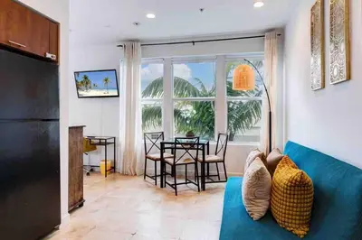 a living room with a blue couch and a table at S BEACH SPOT Heated pool 2BLOCKs to BEACH BBQ in Miami Beach