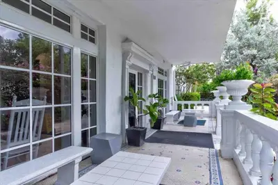 a porch of a white house with benches and plants at S BEACH SPOT Heated pool 2BLOCKs to BEACH BBQ in Miami Beach