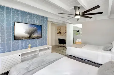 a bedroom with two beds and a tv on a wall at Fort Lauderdale Tropical Oasis Pool Retreat in Fort Lauderdale