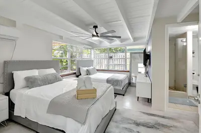 a white bedroom with two beds and a ceiling fan at Fort Lauderdale Tropical Oasis Pool Retreat in Fort Lauderdale