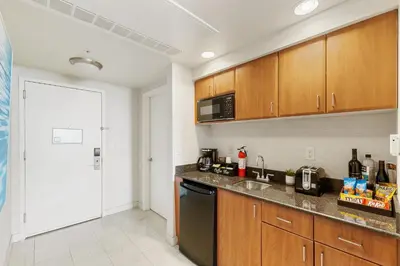 a kitchen with wooden cabinets and a black dishwasher at Lujoso apartamento en playa de Sunny Isles Beach in Sunny Isles Beach