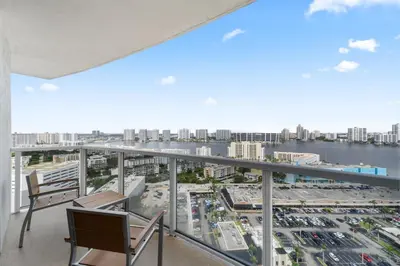 a balcony with chairs and a view of a city at Lujoso apartamento en playa de Sunny Isles Beach in Sunny Isles Beach