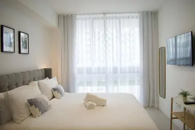 a bedroom with a large white bed with a window at Luxury apartment in Doral miami, 1 Bd in Miami