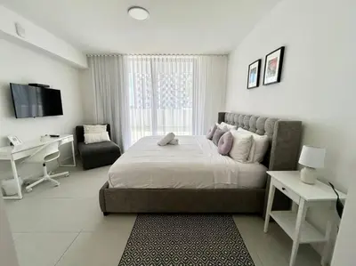 a bedroom with a bed and a desk and a computer at Comfortable Studio suites in downtown Doral in Miami