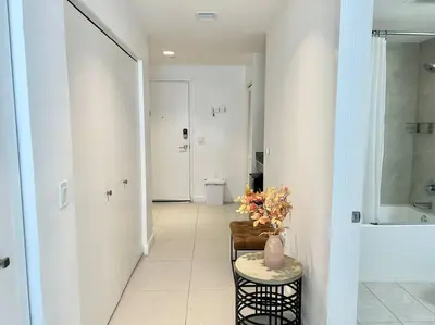 a room with a hallway with a vase of flowers on a table at Comfortable Studio suites in downtown Doral in Miami