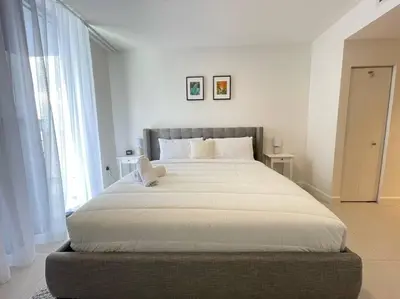 a large bed in a bedroom with a large window at Comfortable Studio suites in downtown Doral in Miami