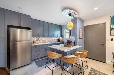 a kitchen with a stainless steel refrigerator and bar stools at The SurfSide Hideout Charming Cozy Central in Miami