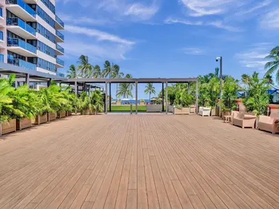 a large patio with chairs and trees and a building at High Floor Adorable 2 Bedroom Condo Resort 1606 in Miami Beach