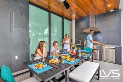 a group of people in a kitchen with a table at Carlotta- New Construction Luxury Waterfront Villa in Fort Lauderdale