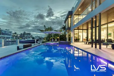 a swimming pool in front of a house at Carlotta- New Construction Luxury Waterfront Villa in Fort Lauderdale