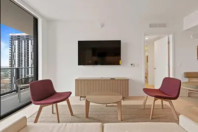 a living room with two chairs and a table and a tv at Orange Crush - Resort-Style Amenities & Location in Miami