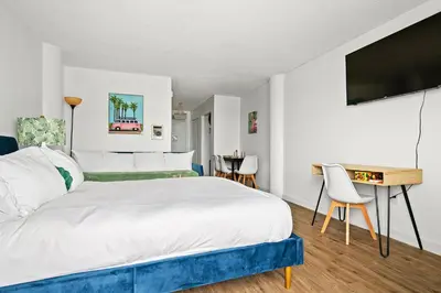 a bedroom with a bed and a desk and a television at Palms 811 in Miami Beach