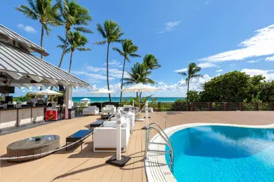 a resort with a swimming pool and palm trees at 2BR Pool Ocean View in Miami Beach