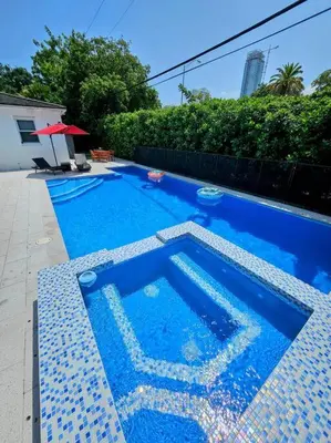 a small blue swimming pool with a tile floor at Brickell Enclave Sunny Retreat with pool in Miami
