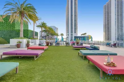 a row of chaise lounges on a lawn with palm trees at 1BR Apartment - Near Beach - Amazing pool in Hollywood