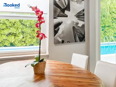 a table with a vase with a flower on it at HOUSE WITH POOL and BBQ, 12 MIN to the BEACH in Miami Shores